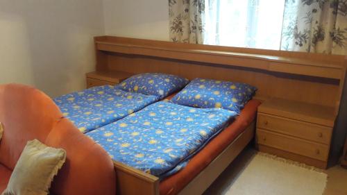 una cama con almohadas azules junto a una ventana en Penzion Dora, en Český Krumlov