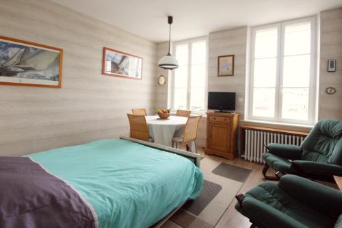 フェカンにあるLe quai Maupassantのベッドルーム1室(ベッド1台、テーブル、椅子付)