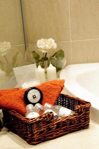 a basket of bathroom items on a counter next to a sink at Summer Garden Guest House (The Palms) in Benoni