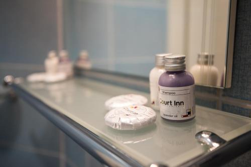 a bottle of purple liquid sitting on a bathroom counter at Court Inn in Panagyurishte