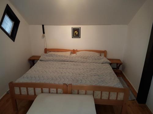 ein kleines Schlafzimmer mit einem Bett und einer Bank in der Unterkunft Apartment Labud in Legrad