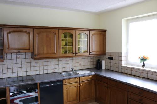 a kitchen with wooden cabinets and a sink and a window at Zur Alpenruhe in Seeboden