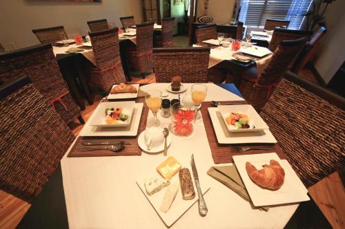 a table in a restaurant with plates of food at Summer Garden Guest House (The Palms) in Benoni