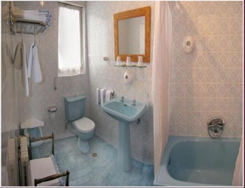 y baño con lavabo, aseo y bañera. en Hostal Toscana, en Ojedo