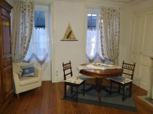 un salon avec une table et une chaise dans l'établissement la Tourelle en Normandie, à Saint-Pierre-Église