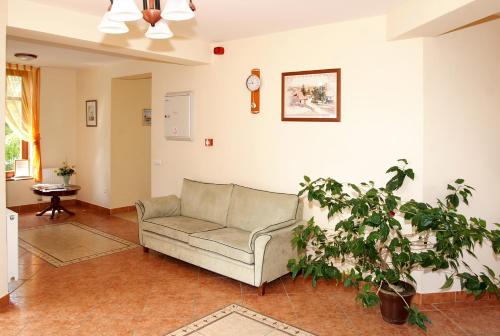 a living room with a couch and a plant at Pihenőkereszt Panzió in Sopron
