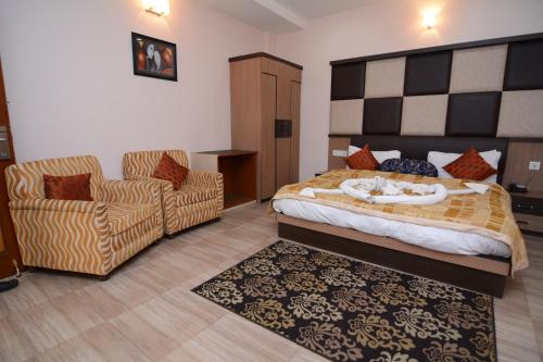 a bedroom with a bed and a couch and a chair at Hotel Royal Highness in Tinsukia