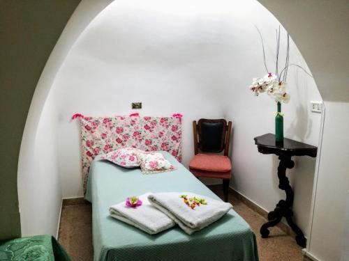 een kamer met een bed en een stoel met handdoeken bij B&B Aquila in Alberobello