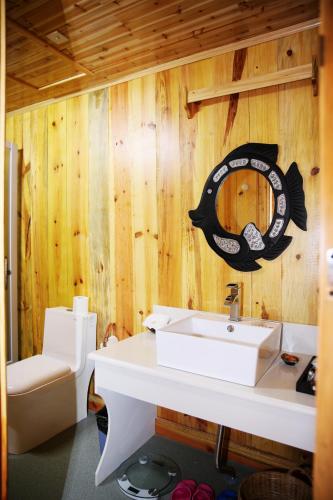 a bathroom with a sink and a fish decal on the wall at Dai Yuan Inn in Mengla