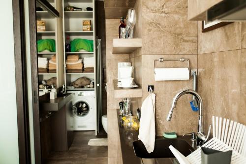 a bathroom with a sink and a washing machine at Okolnik Apartment in Warsaw
