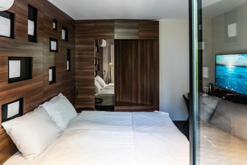 a bedroom with a large white bed and a tv at Best Western Premier Natalija Residence in Belgrade