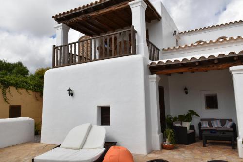 a white house with a balcony on a patio at Can Gat in Sant Carles de Peralta