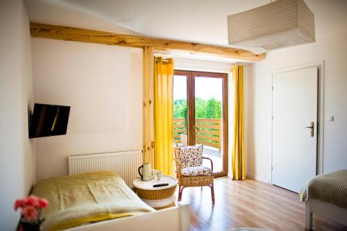 een slaapkamer met een bed, een stoel en een raam bij Miodowy Zakątek Całoroczne domki i pokoje przy Suntago, Deepspot in Mszczonów