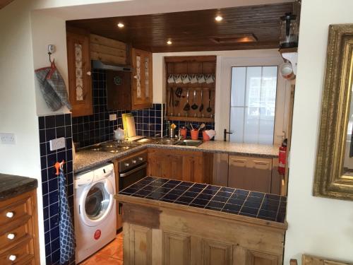 a kitchen with a sink and a washing machine at Erin Cottage in Derry Londonderry