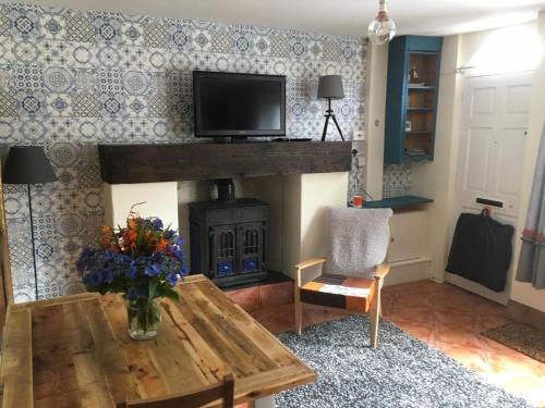 a living room with a wooden table and a fireplace at Erin Cottage in Derry Londonderry