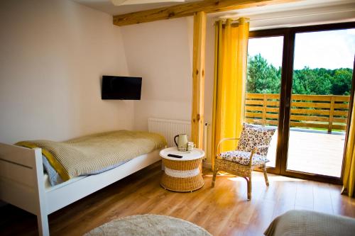 a bedroom with a bed and a chair and a window at Miodowy Zakątek Całoroczne Domki i Pokoje przy Suntago, Deepspot, Pyszne Śniadania, Grill in Mszczonów