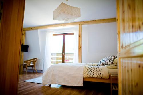 a bedroom with a bed with a wooden frame and a window at Miodowy Zakątek Całoroczne Domki i Pokoje przy Suntago, Deepspot, Pyszne Śniadania, Grill in Mszczonów
