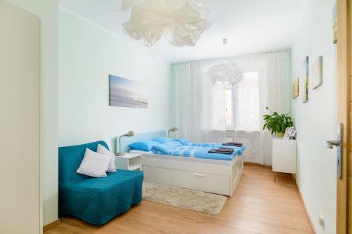 1 dormitorio con 1 cama azul y 1 sofá azul en Plac Wielkopolski Apartment en Poznan