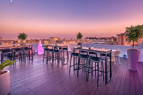 a rooftop bar with tables and chairs on a deck at Veramar Aparthotel in Fuengirola