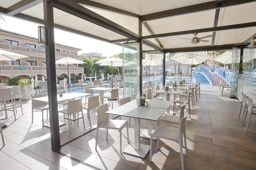 a restaurant with tables and chairs and a water slide at Mon Port Hotel & Spa in Port d’Andratx