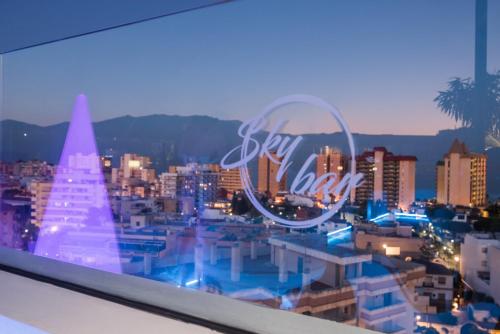 a view of a city at night with a neon sign at Veramar Aparthotel in Fuengirola