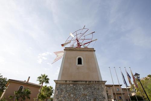 a clock tower with a windmill on top of it at Mon Port Hotel & Spa in Port d’Andratx