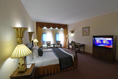 a hotel room with a bed and a flat screen tv at Imperial Resort Beach Hotel in Entebbe