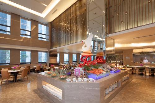 a lobby with a food counter in a restaurant at Ramada Jinan in Jinan