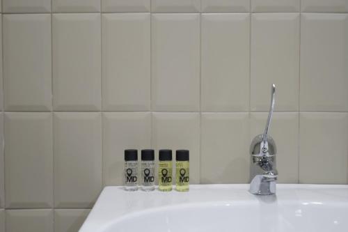 a white tiled bathroom with a white sink at MD Design Hotel - Portal del Real in Valencia