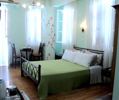 a bedroom with a bed with a green comforter at Filyra Pension in Nafplio