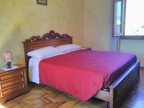 ベヴァーニャにあるAgriturismo "Vecchia Fattoria"のベッドルーム1室(赤毛布付きの大型ベッド1台付)
