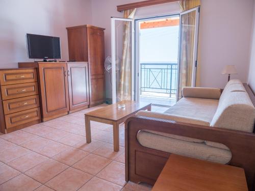 a living room with a couch and a tv at Maria Apartments in Agios Georgios Pagon