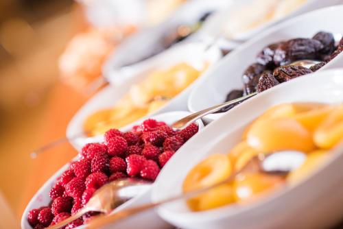 a plate of food with raspberries and other desserts at Hotel Mühlenerhof in Campo Tures