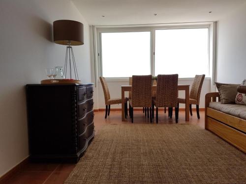 アルマカオ・デ・ペラにあるMarisol Apt Algarveのリビングルーム(テーブル、椅子、ソファ付)