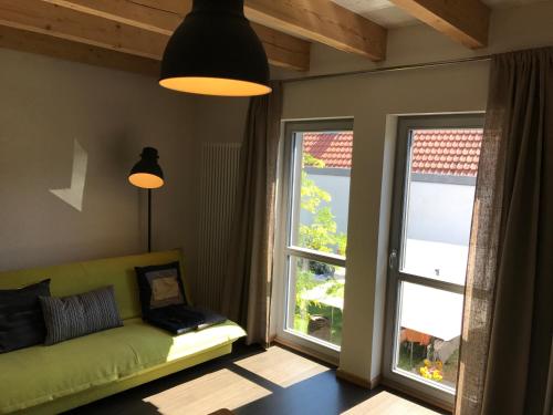 a living room with a green couch and a window at Blackbird´s Nest in Wiesenbronn