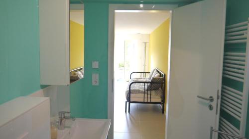y baño con lavabo y paredes de color verde y amarillo. en Studio im Haus in Seenähe en Reinfeld