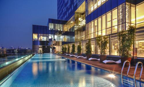 a swimming pool in front of a building at night at Vertu Harmoni Jakarta in Jakarta