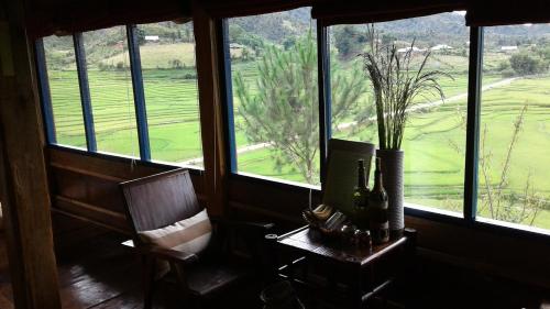 a room with a chair and a vase with a plant at Mu Cang Chai Eco Lodge in Nam San