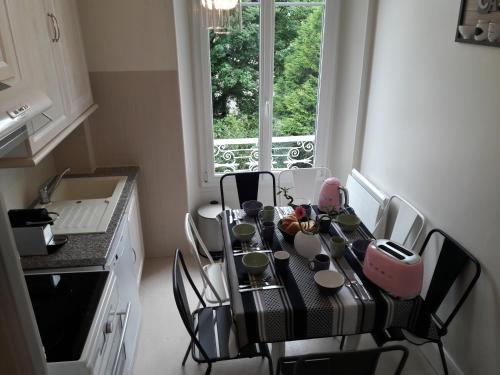 a kitchen with a table with chairs and a window at La Demeure d'Elodie in Épernay
