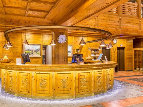 a bar in a wooden building with a clock at Sport Hotel Village in Soldeu