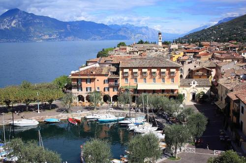 a town with boats docked in a harbor next to the water at Albergo Gardesana in Torri del Benaco