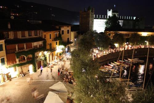 a city street at night with a crowd of people at Albergo Gardesana in Torri del Benaco