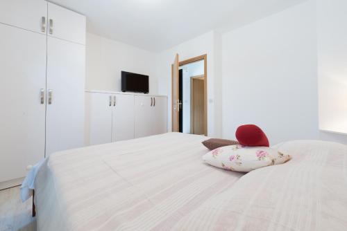 a white bed with a stuffed animal sitting on it at City Center Suites - Apartment with Terrace and Private Pool in Cavtat