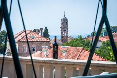 a view of a town from a balcony with wine glasses at City Center Suites - Apartment with Terrace and Private Pool in Cavtat