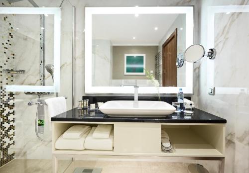 a bathroom with a sink and a shower at Renaissance Minsk Hotel in Minsk