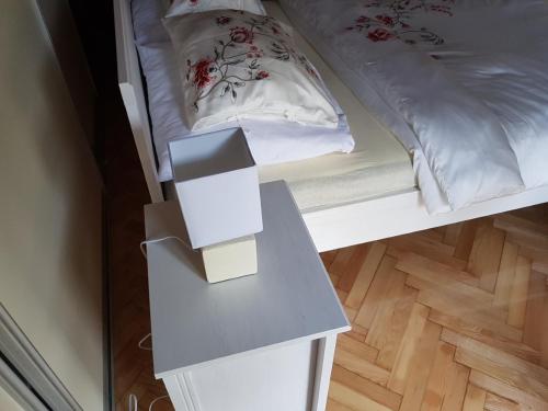 a white bed with a table next to it at Apartments Kamenecki in Krapina