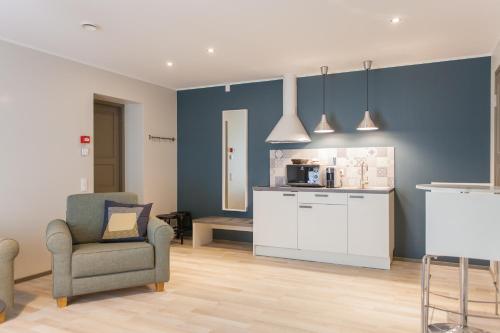 a living room with a chair and a kitchen at Johan Suites & Spa in Kuressaare