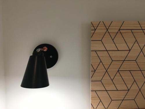 a black lamp on a wall next to a wall at MD Design Hotel - Portal del Real in Valencia