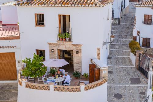 two people sitting at a table outside of a building at "El Porton" (El Borge ,Malaga). in Borge