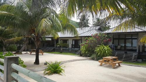 a building with two picnic tables in front of it at Fleur de Sel in Mahe